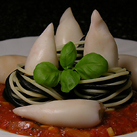 Calamari mit Tomatensauce und schwarz-weißen Spaghetti